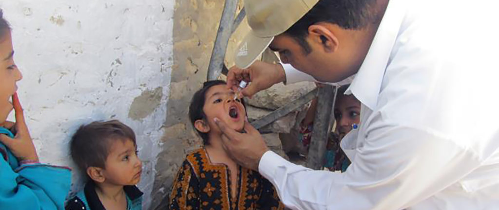 Un voluntario vacuna a un niño pakistaní durante una campaña de vacunación contra la polio en Pakistán en julio de 2011